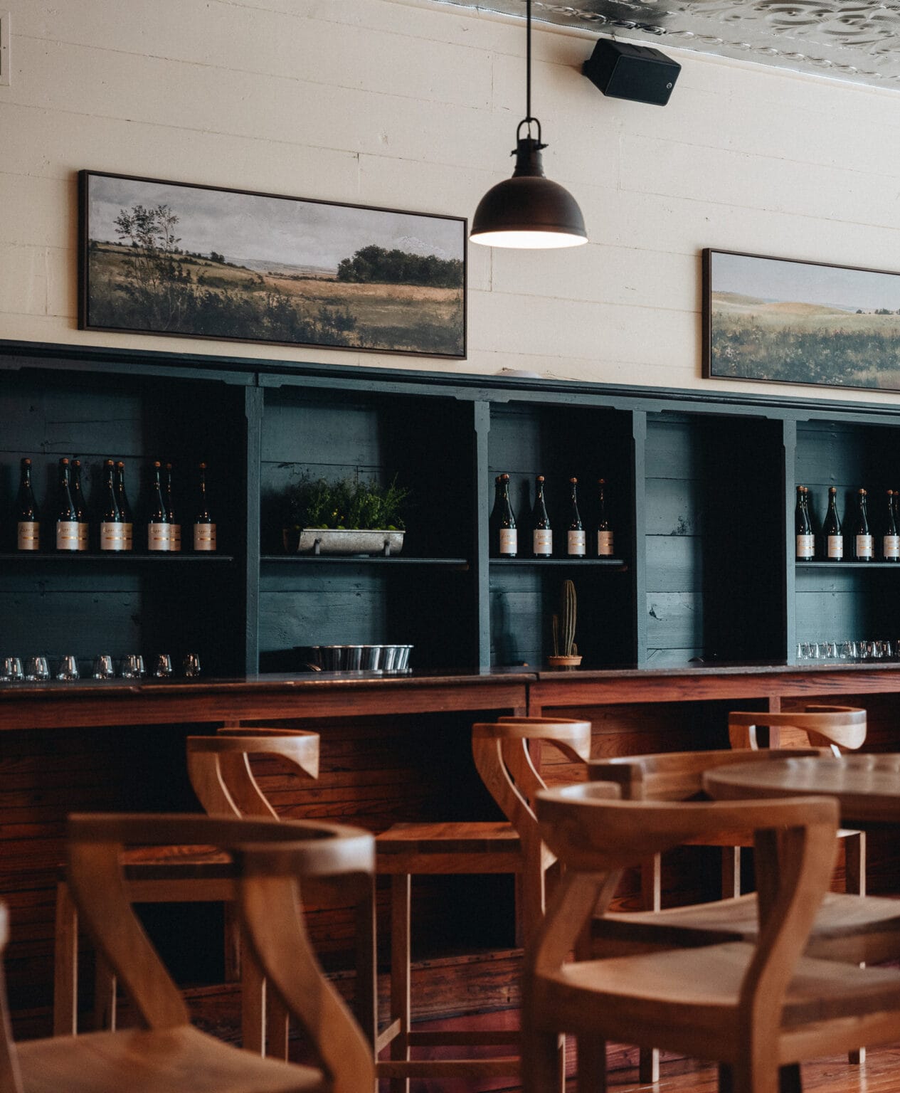 The tasting room bar in the 1904 Hye post office, bottles lined on the back shelves