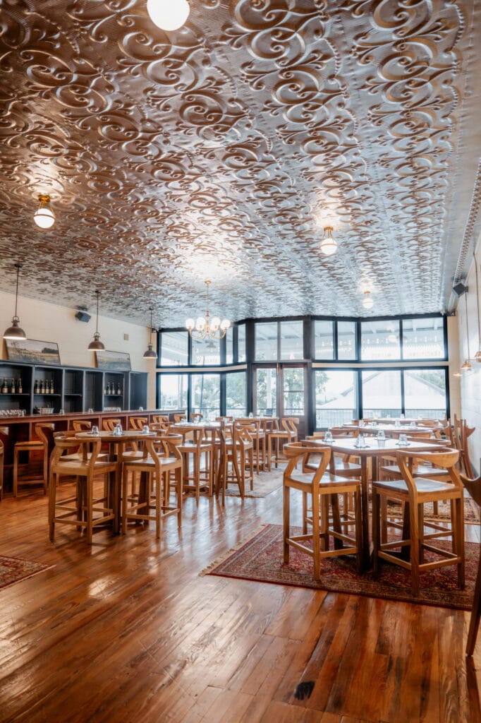 Wooden tables and chairs beneath the pressed-tin ceiling of the Hye post office tasting room