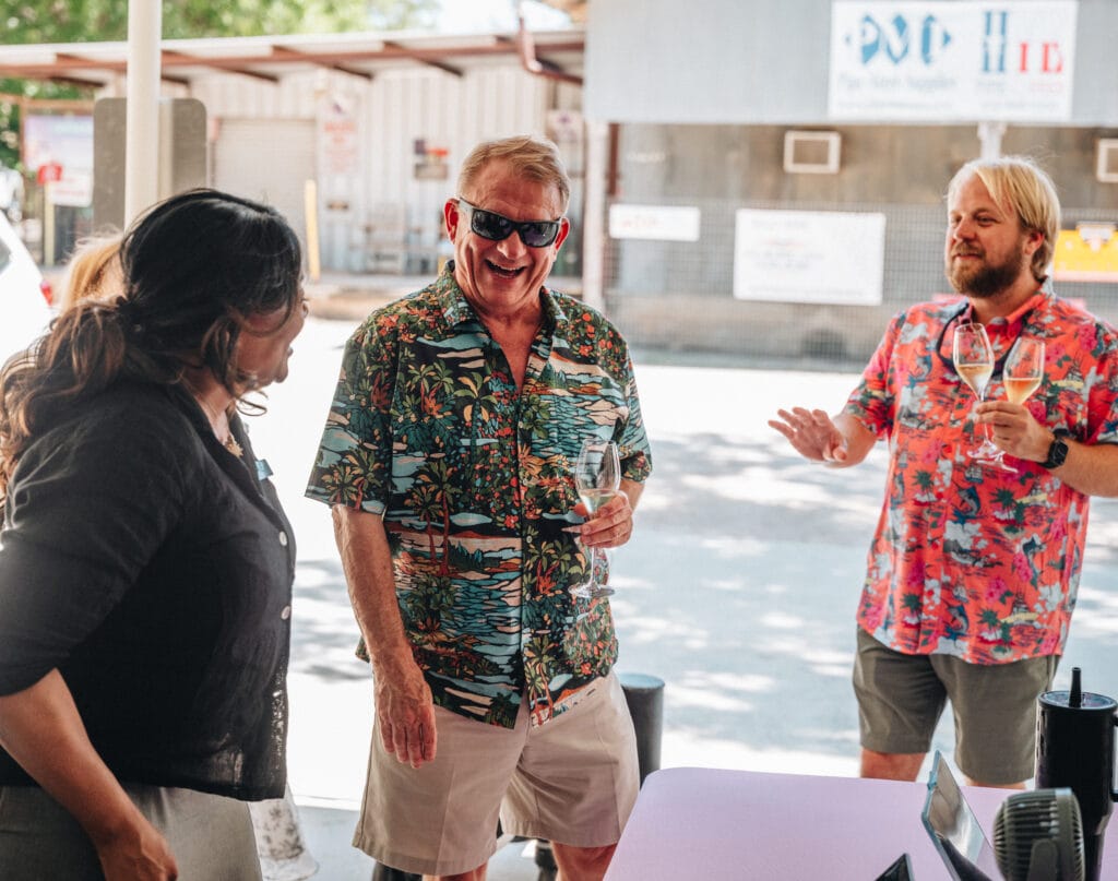 Guests laughing with a host at an outdoor pour on the property