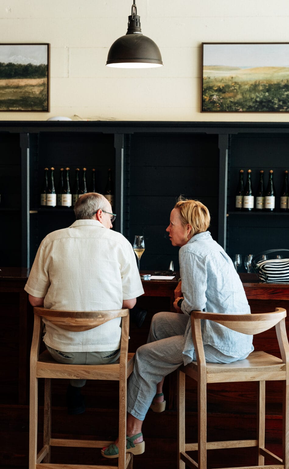 Two guests seated at the tasting room bar in the main room