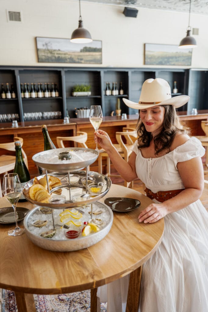 Guests seated around a table in the Rebecca Caroline tasting room with glasses and small plates