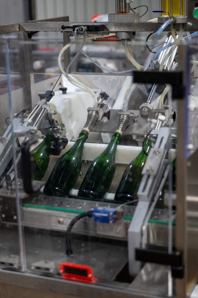Bottles moving along the disgorging line in the Rebecca Caroline cellar